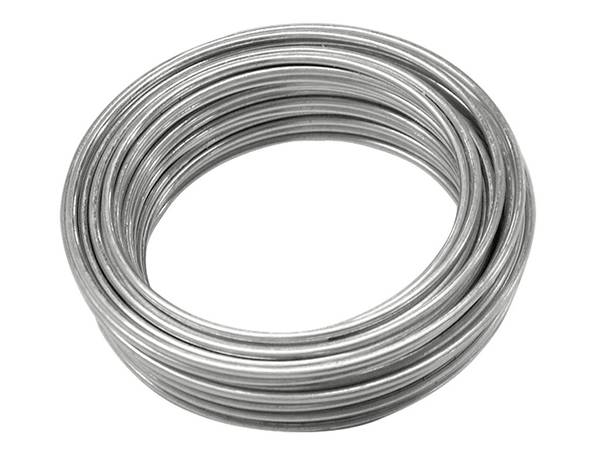 A coil of aluminum spring wire is on the white ground.