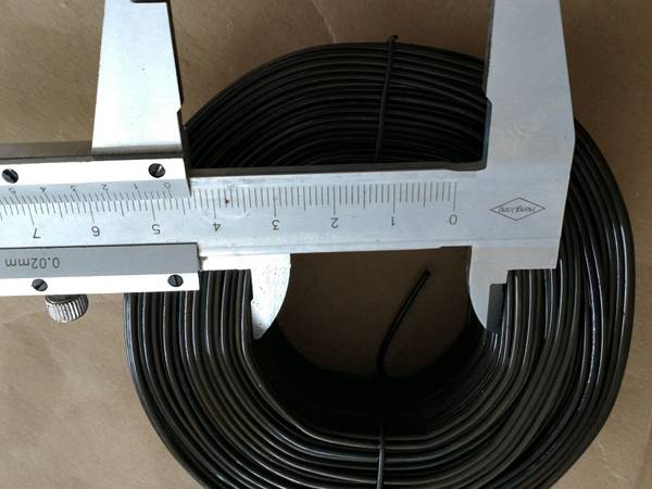 A vernier caliper is measuring the diameter of rebar tie wire.